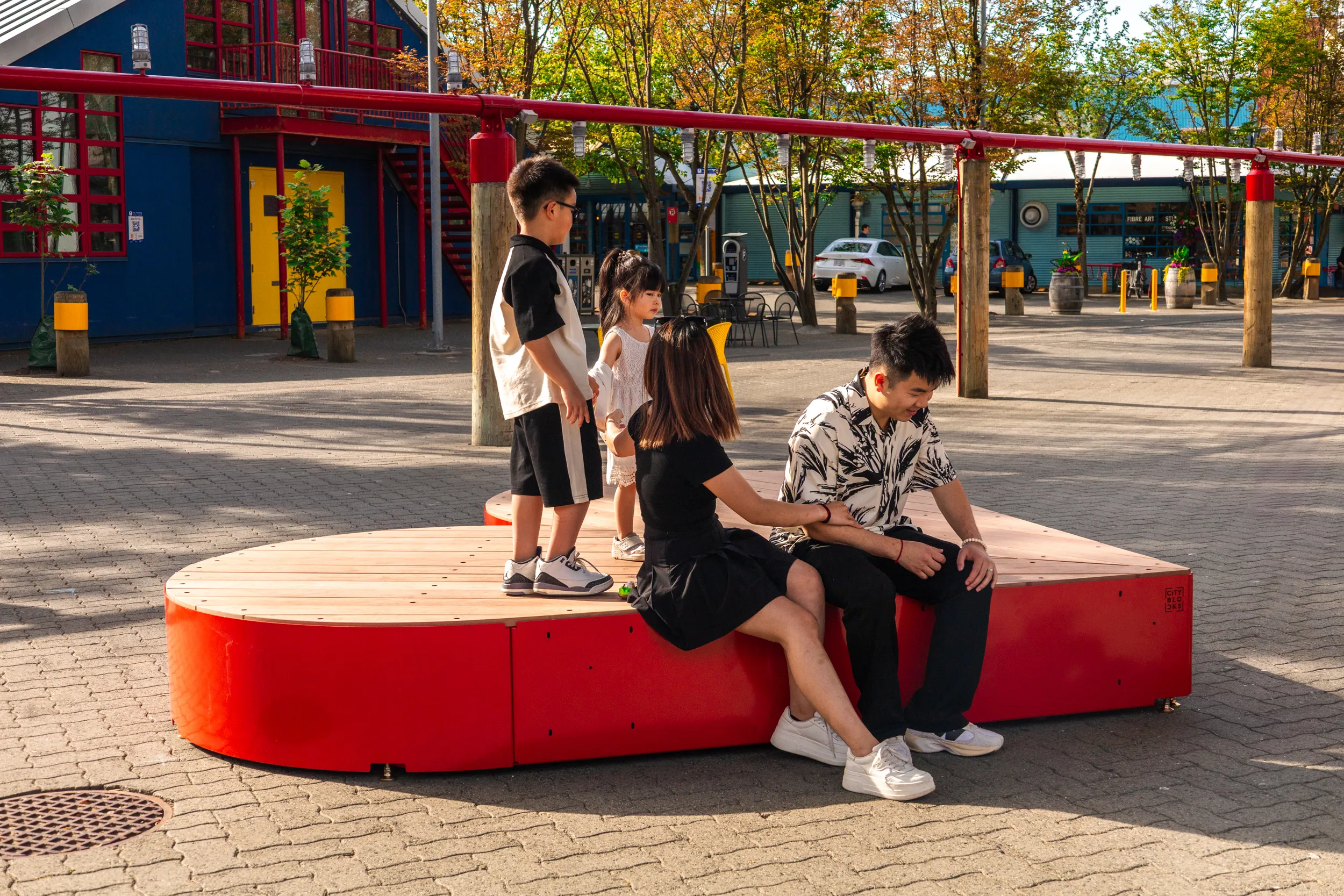 A family sitting on a large, heart-shaped bench