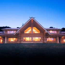A Pioneer Log Homes log house at dusk
