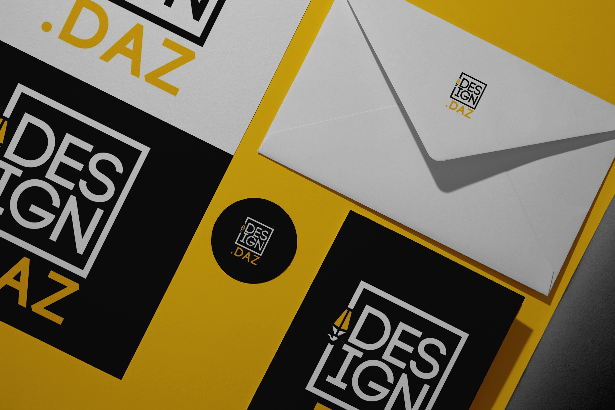Branding materials including cards, envelope, and a round sticker featuring a modern DESIGN DAZ logo with a yellow and black color scheme.