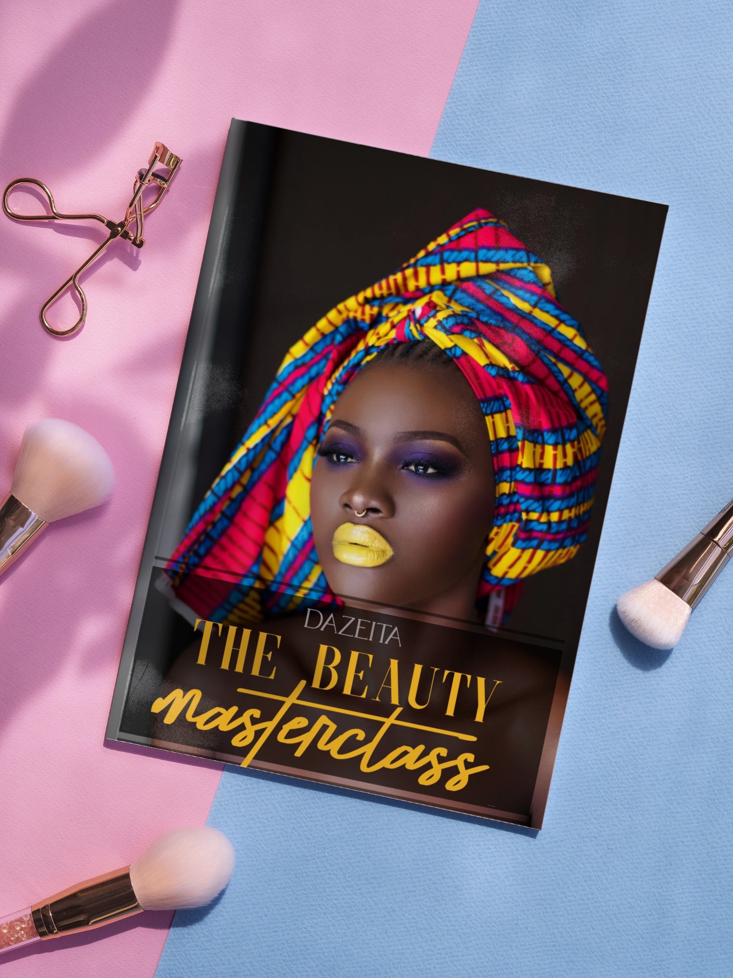 Magazine cover titled 'The Beauty Masterclass' featuring a woman with bold yellow lipstick and a colorful headwrap, surrounded by makeup brushes and an eyelash curler on a pink and blue background.