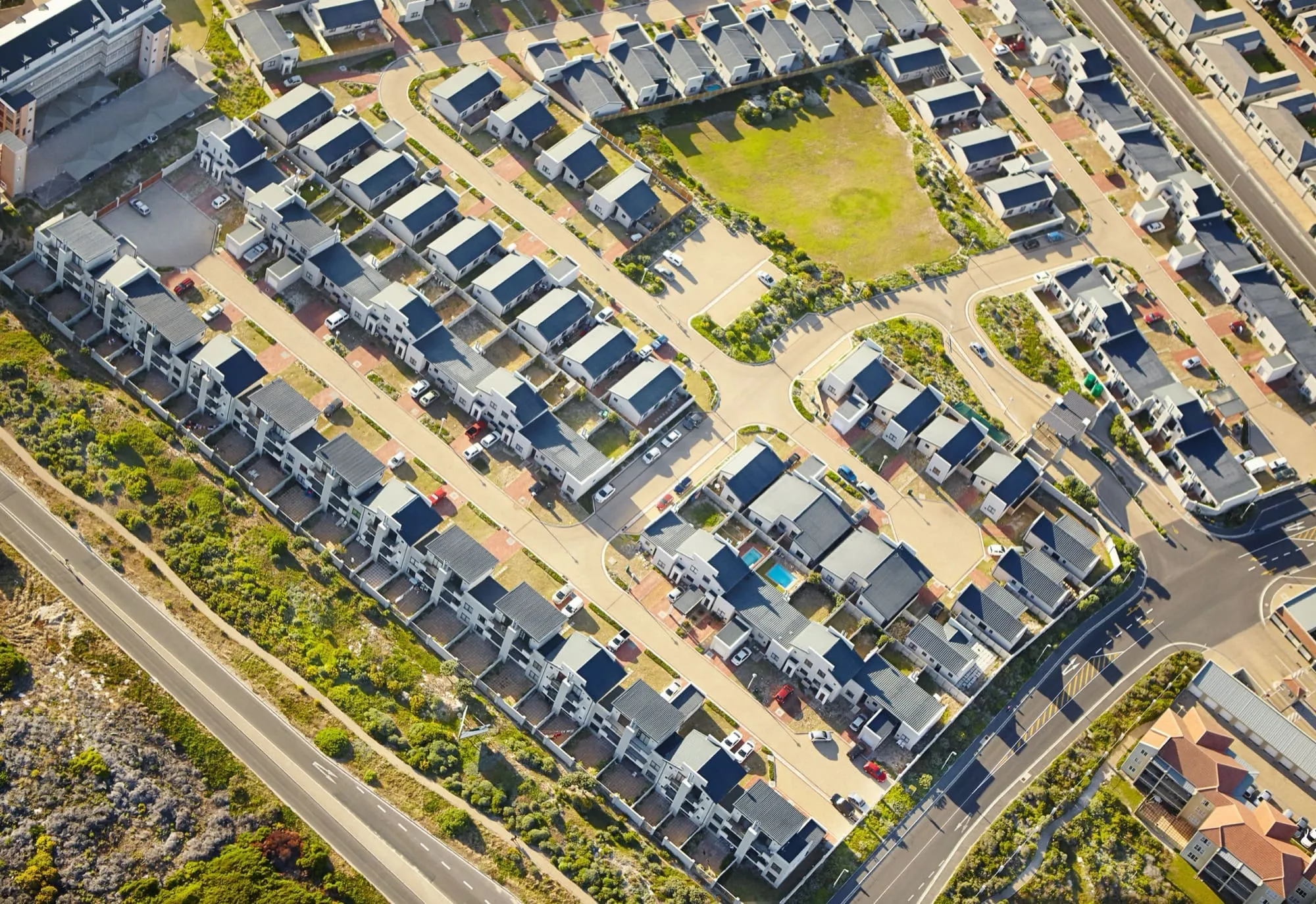 Aerial view of a modern suburban neighborhood with rows of houses and streets.