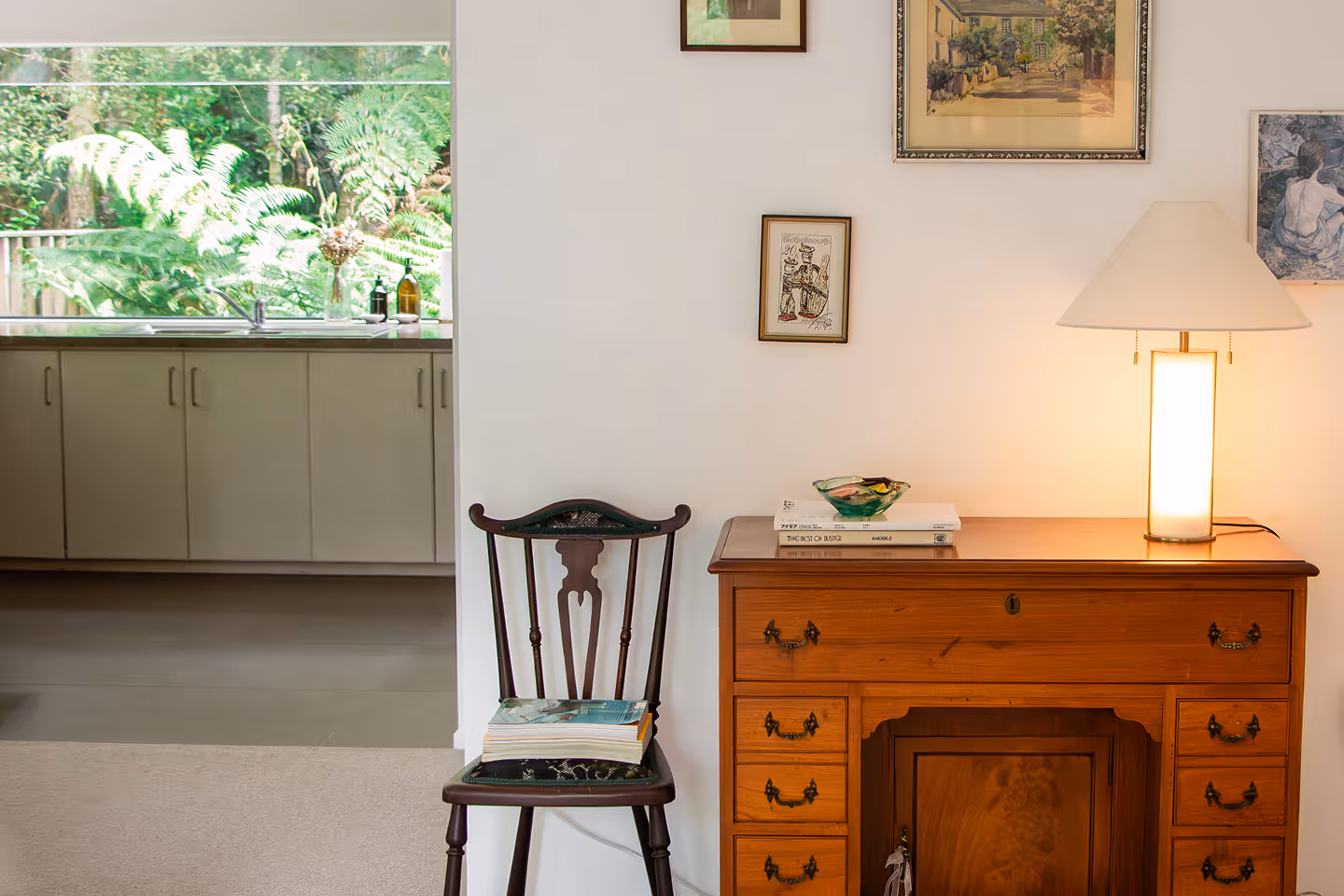Styled corner with vintage chair, books, and wooden desk in an Auckland Airbnb managed by Homello