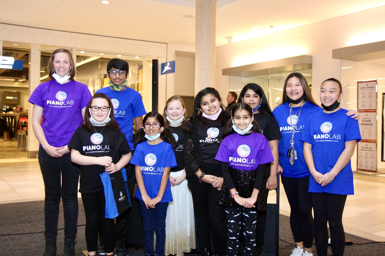 A kid with headphones sitting at a piano