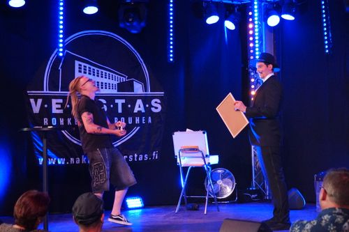 Taikuri Antti Kalliokoski esiintyy lavalla ja yleisö nauraa. Hauskaa ohjelmaa aikuisten juhliin.