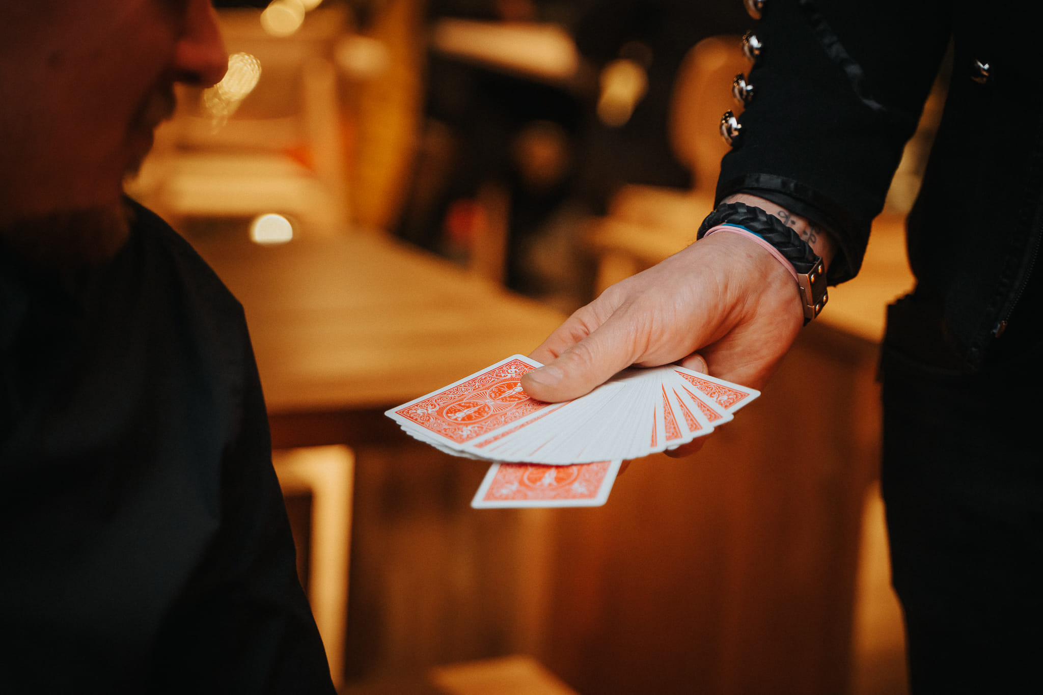 Taikuri Antti Kalliokoski esittää korttitemppua ravintolassa