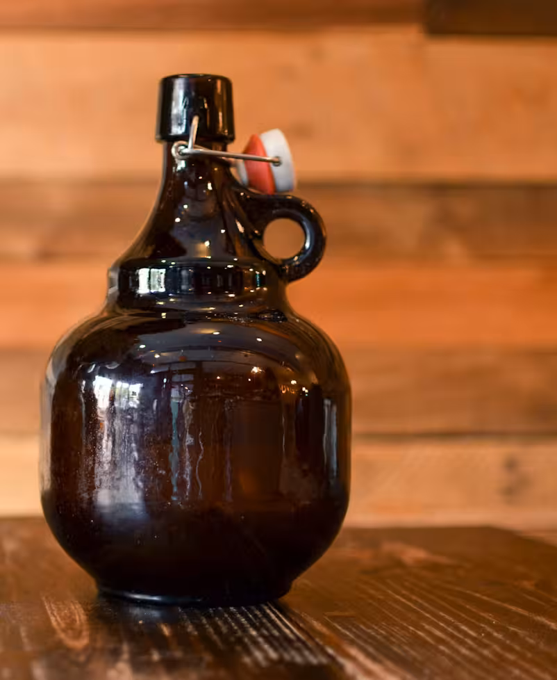 Photographie d'une bouteille growler en verre sombre, équipée d'un bouchon mécanique
