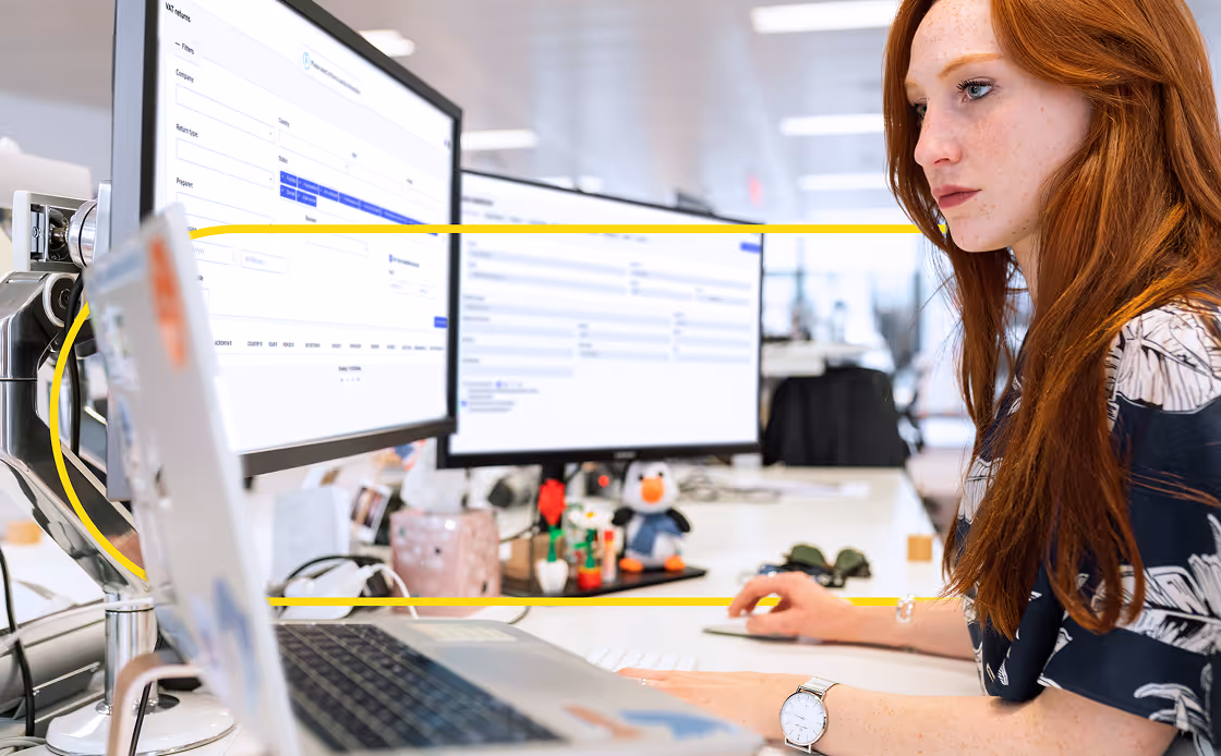 woman working in the office with computer and two screens