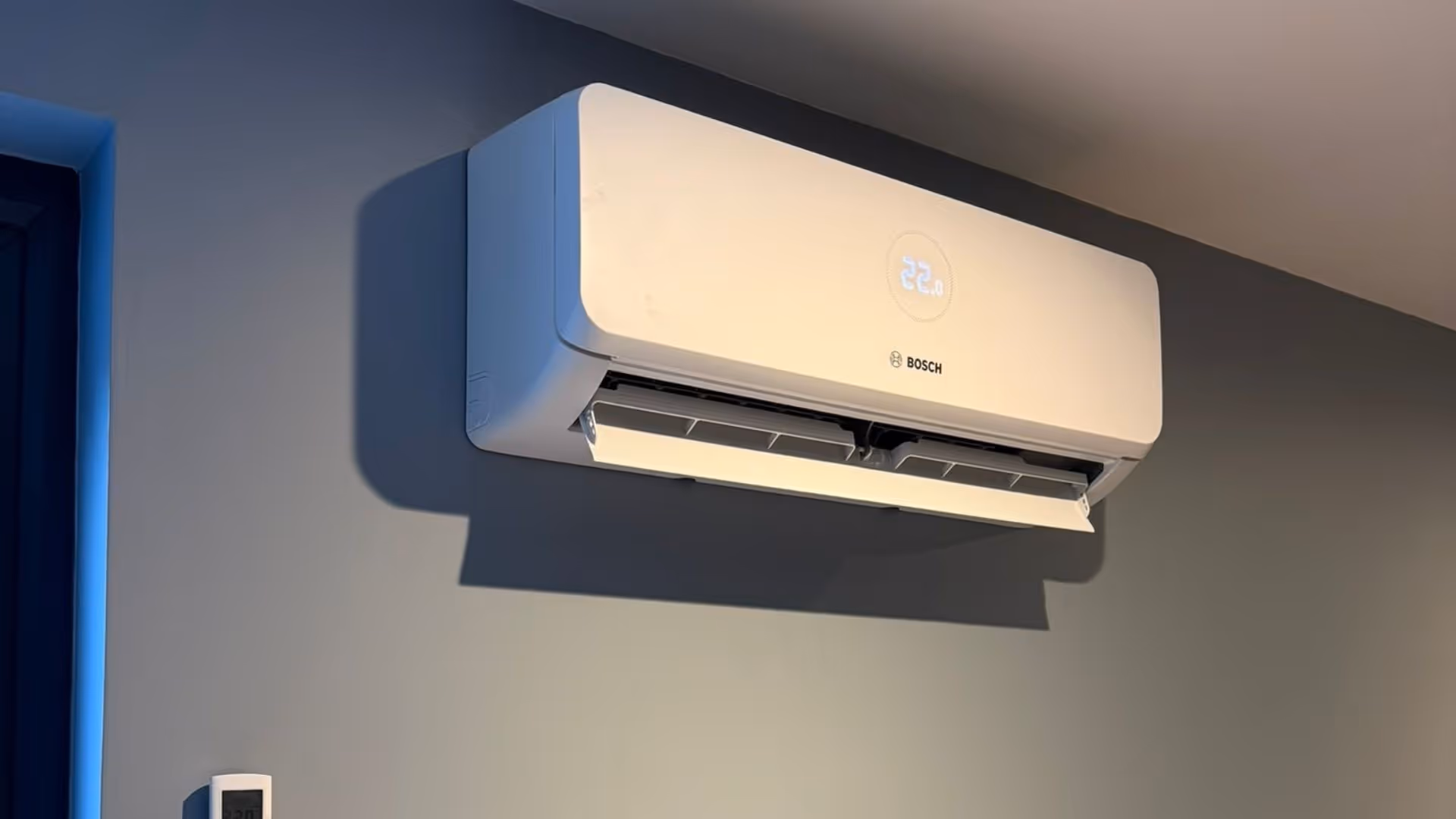 A wall-mounted air conditioner displaying the temperature setting on the front panel.