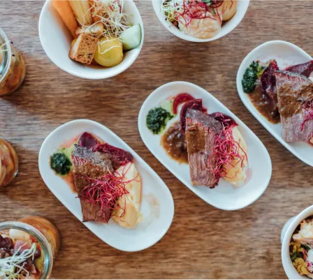 Herzhafte Gerichte mit Fleisch, Kartoffeln und Gemüse, kombiniert nach Anlass und Bedarf, stilvoll angerichtet für ein Catering-Event.