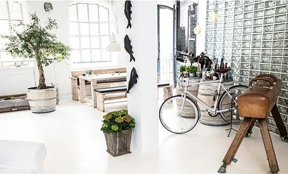 Lichtdurchflutetes Loftstudio mit Lounge-Bereich, weißen Wänden und großen Fenstern – vielseitige Mietlocation Hamburg.