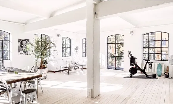 Großzügiges Loft mit Fitnessgerät, weißen Wänden und großen Fenstern – vielseitige Location Hamburg für Produktionen.