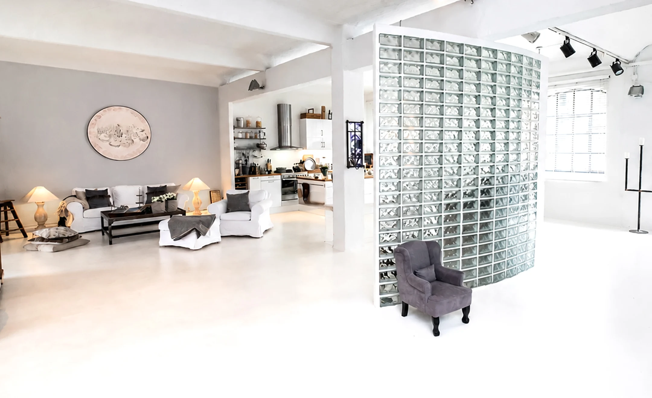 Eventfläche mit Glasbausteinwand – Helles Studio mit Glaswand, Tischkicker und modernen Sitzmöbeln.