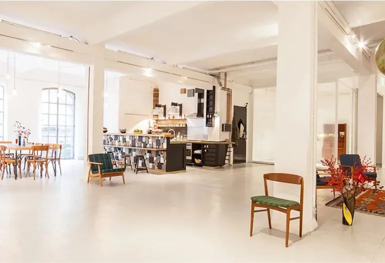 Großzügiges, lichtdurchflutetes Loftstudio mit Esstischen und moderner Einrichtung – Loft mieten Hamburg für Events und Workshops.