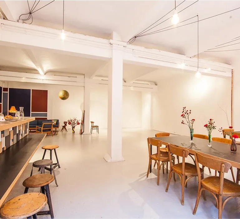 Lichtdurchfluteter Veranstaltungsraum mit Esstischen und Stühlen – Mietlocation Hamburg für Tagungen und Firmenfeiern.