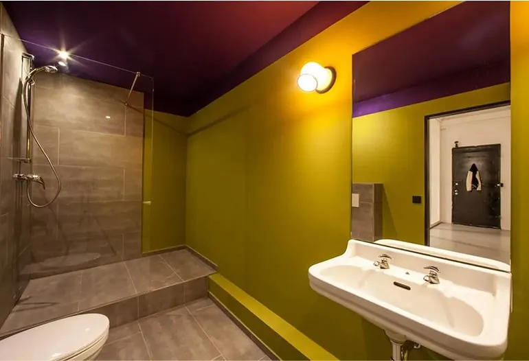 Modernes Badezimmer mit grünen Wänden sowie großer Badewanne – stilvolles Loft Hamburg mit Designerbad.