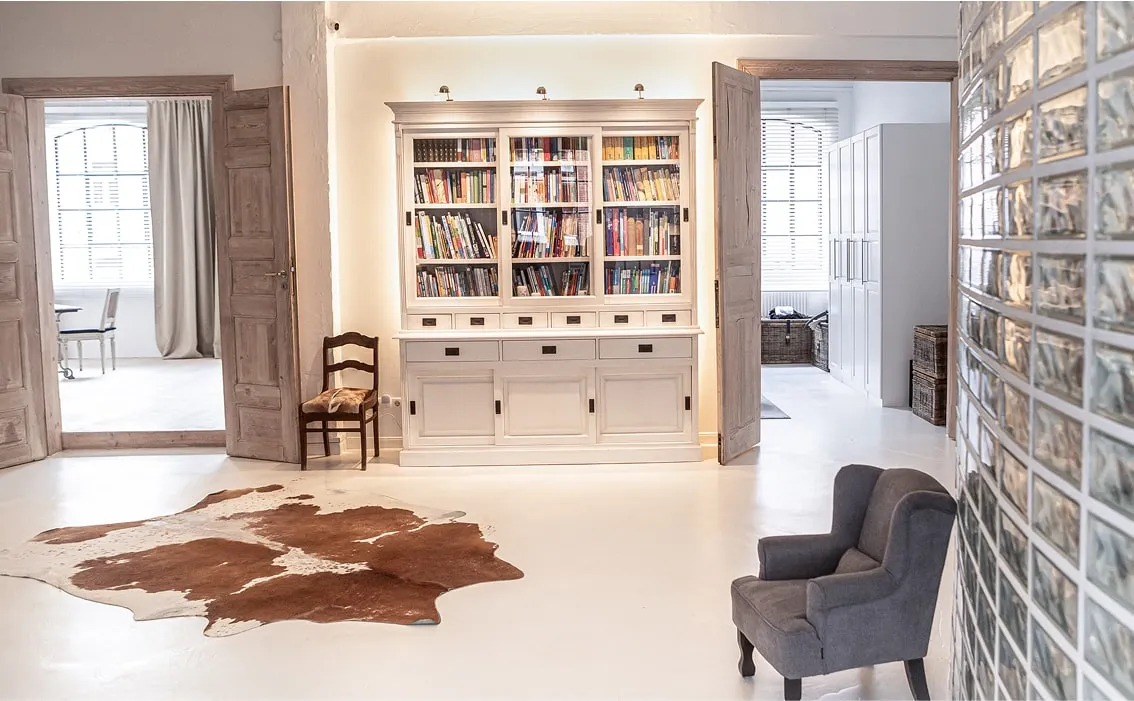 Gemütlicher Studiobereich mit Bücherwand, Lederteppich und Sitzecke – ruhiger Hintergrund für Shootings, Interviews oder kreative Arbeiten in einer Mietlocation Hamburg.