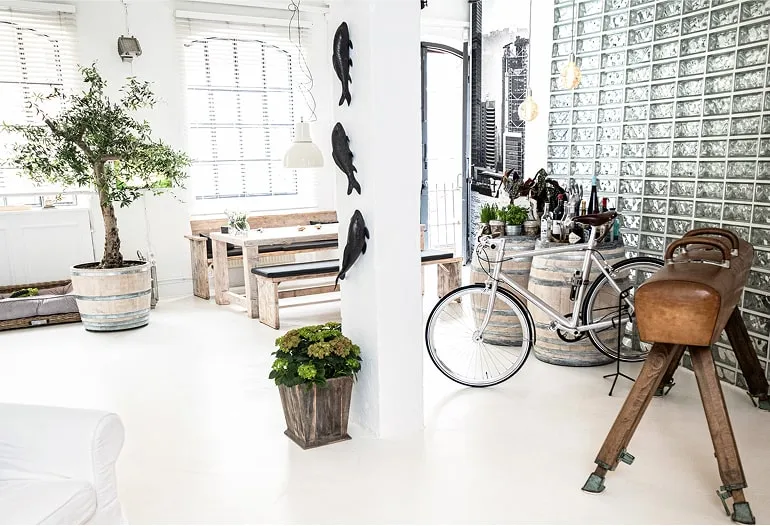 Heller Loftbereich mit großen Fenstern, Pflanzen, Fahrrad und Sitzbank – Loft mieten Hamburg für kreative Events.