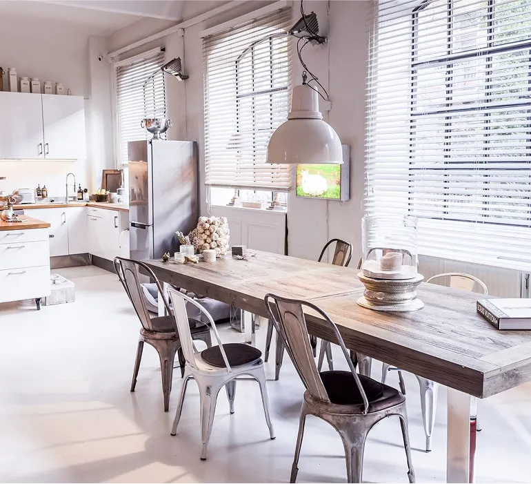 Großer Esstisch mit Stühlen in lichtdurchflutetem Loftstudio, industrielle Lampen – Eventlocation Hamburg für Meetings und Workshops.