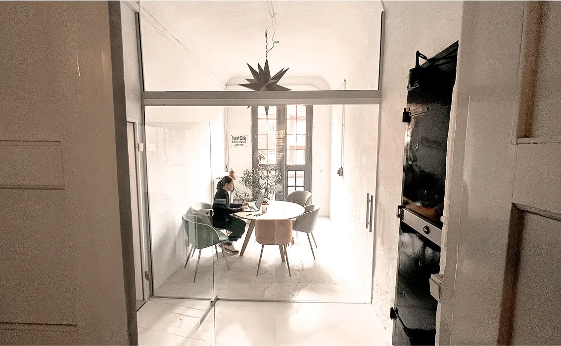 Heller Besprechungsbereich mit rundem Tisch und Designlampe – Tagungsraum oder Meetingraum in zentraler Hamburger Lage.