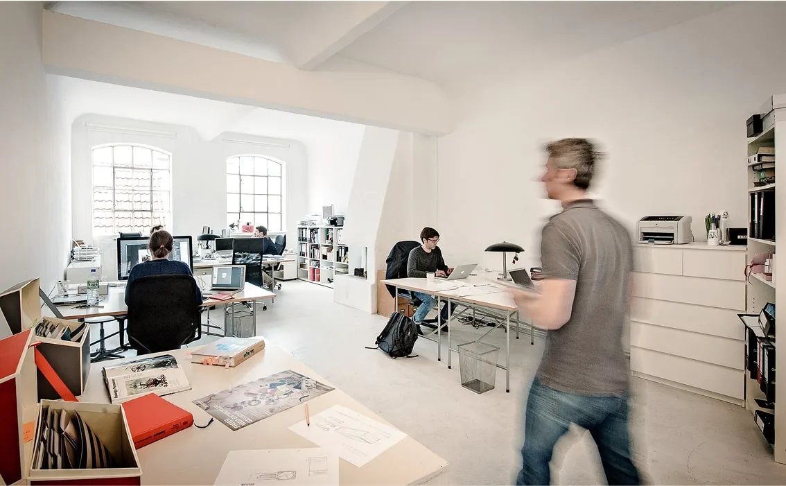 Kreativer Arbeitsbereich mit Schreibtisch, Regalen und viel Tageslicht – Loft mieten Hamburg für Workshops und Projekte.