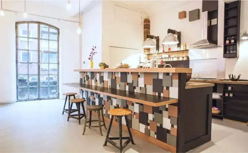 Voll ausgestattetes Loftstudio mit Esstischen, Stühlen und moderner Einrichtung – Mietlocation Hamburg für Seminare.