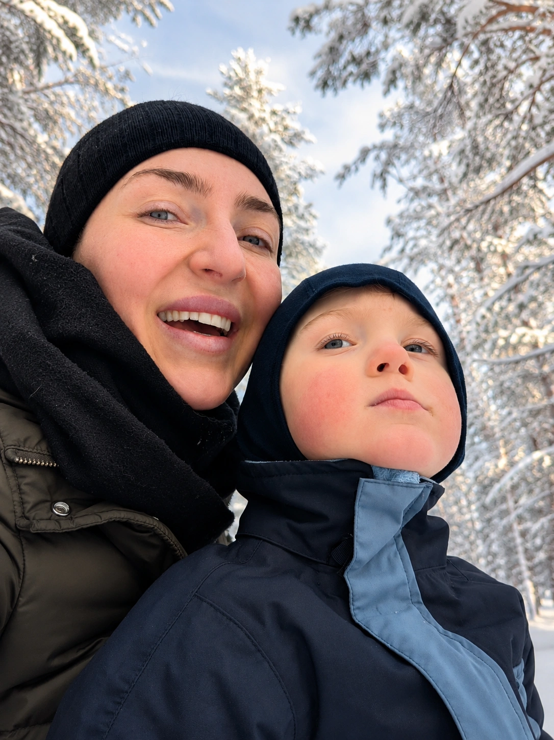 Mother and son enjoying a peaceful winter day in Finnish Lapland.