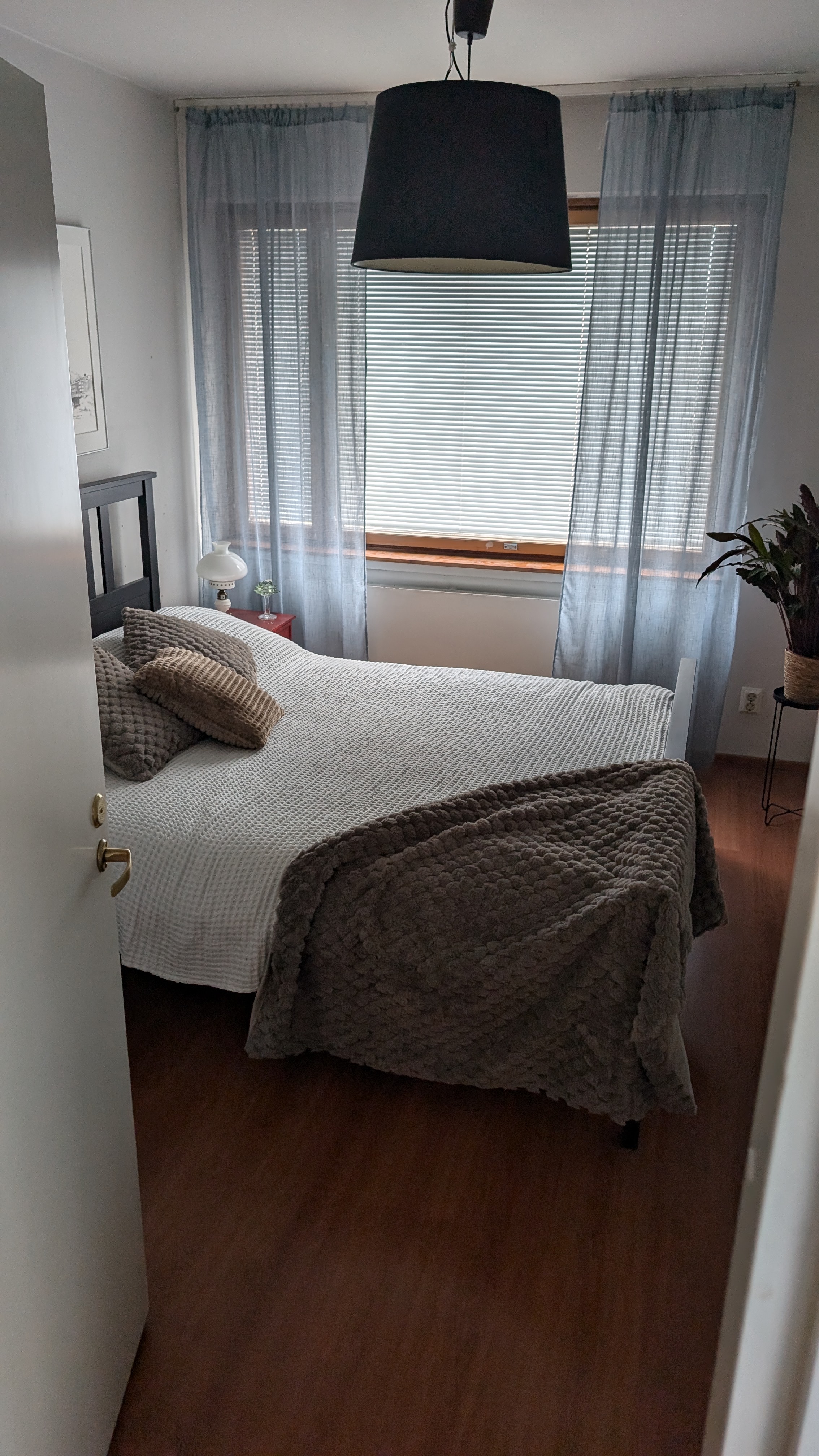 Bedroom with a neatly made white bed in a cozy city apartment in Rovaniemi, Finland