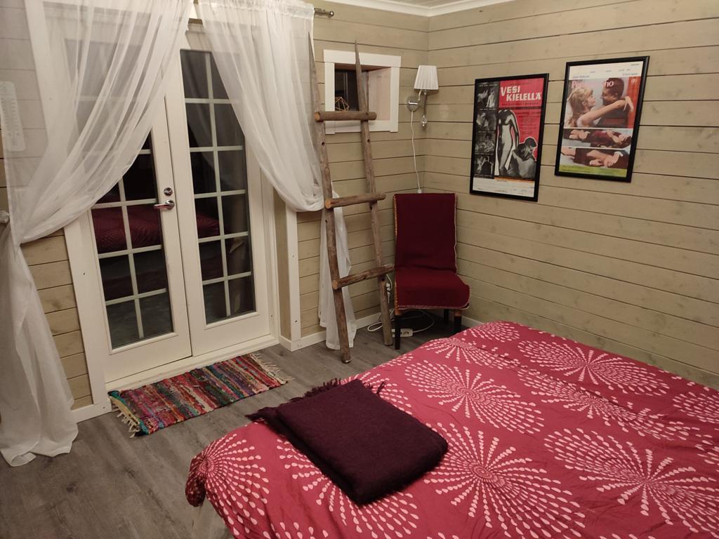 Cosy bedroom in a traditional Finnish sauna cottage with wooden interior