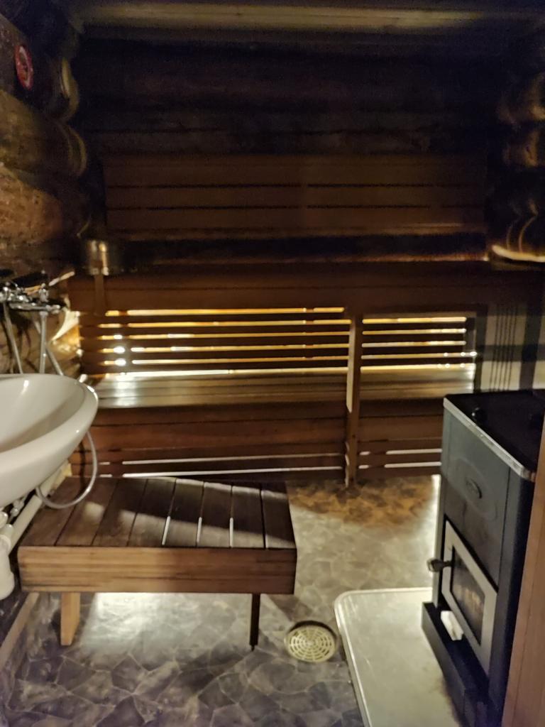 Traditional wood-heated Finnish sauna interior with bench and stove