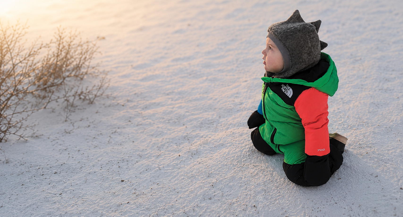 Young child wearing a snowsuit and wool balaclava in Finnish Lapland