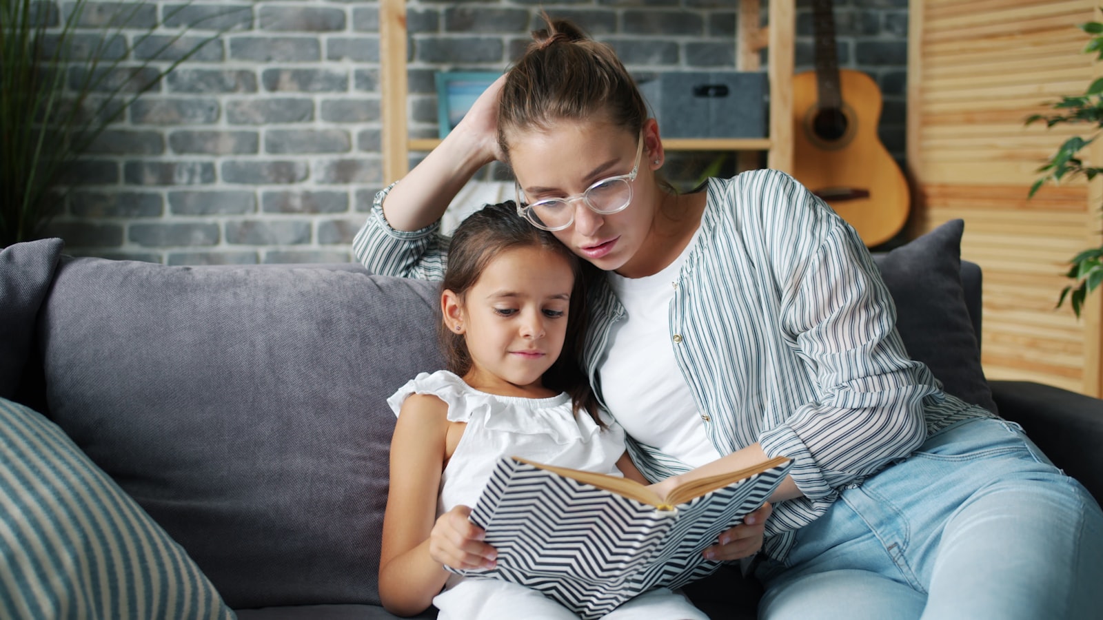 A parent and a school-age child reading a book together at home