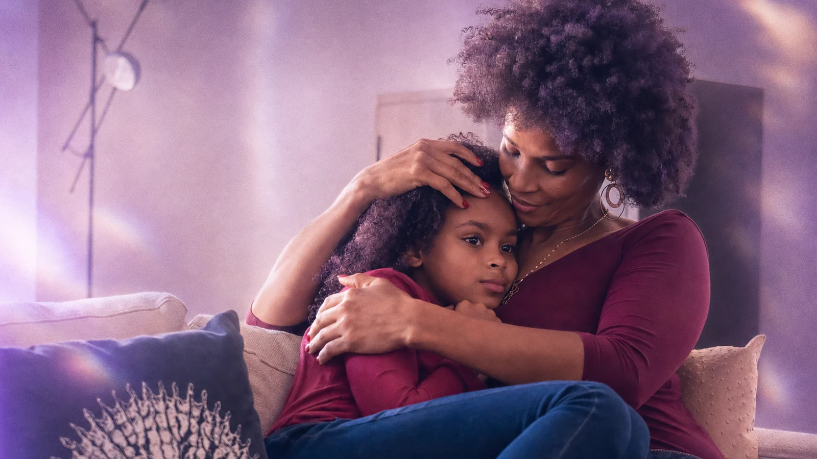 A parent comforting their child on the couch