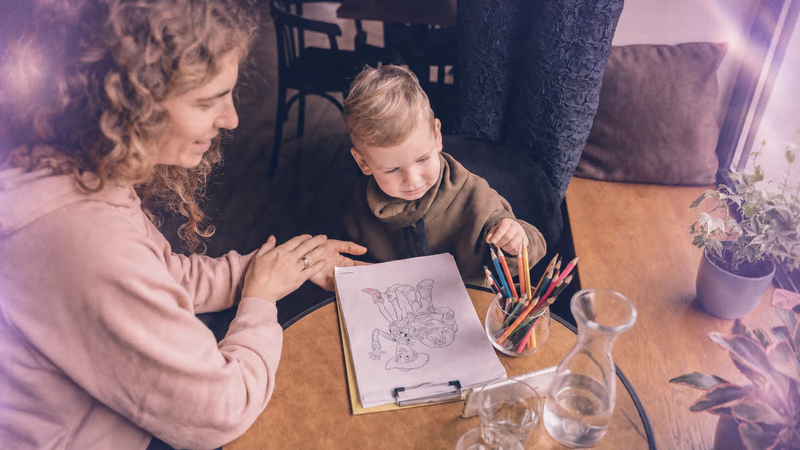 An adult and a young child drawing together at a table