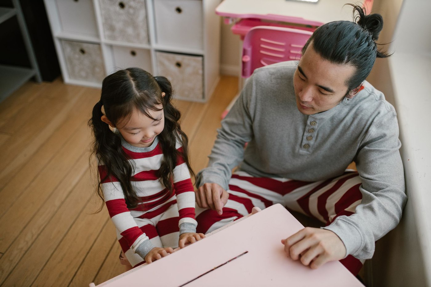 An adult and a child working together at a table on a learning activity
