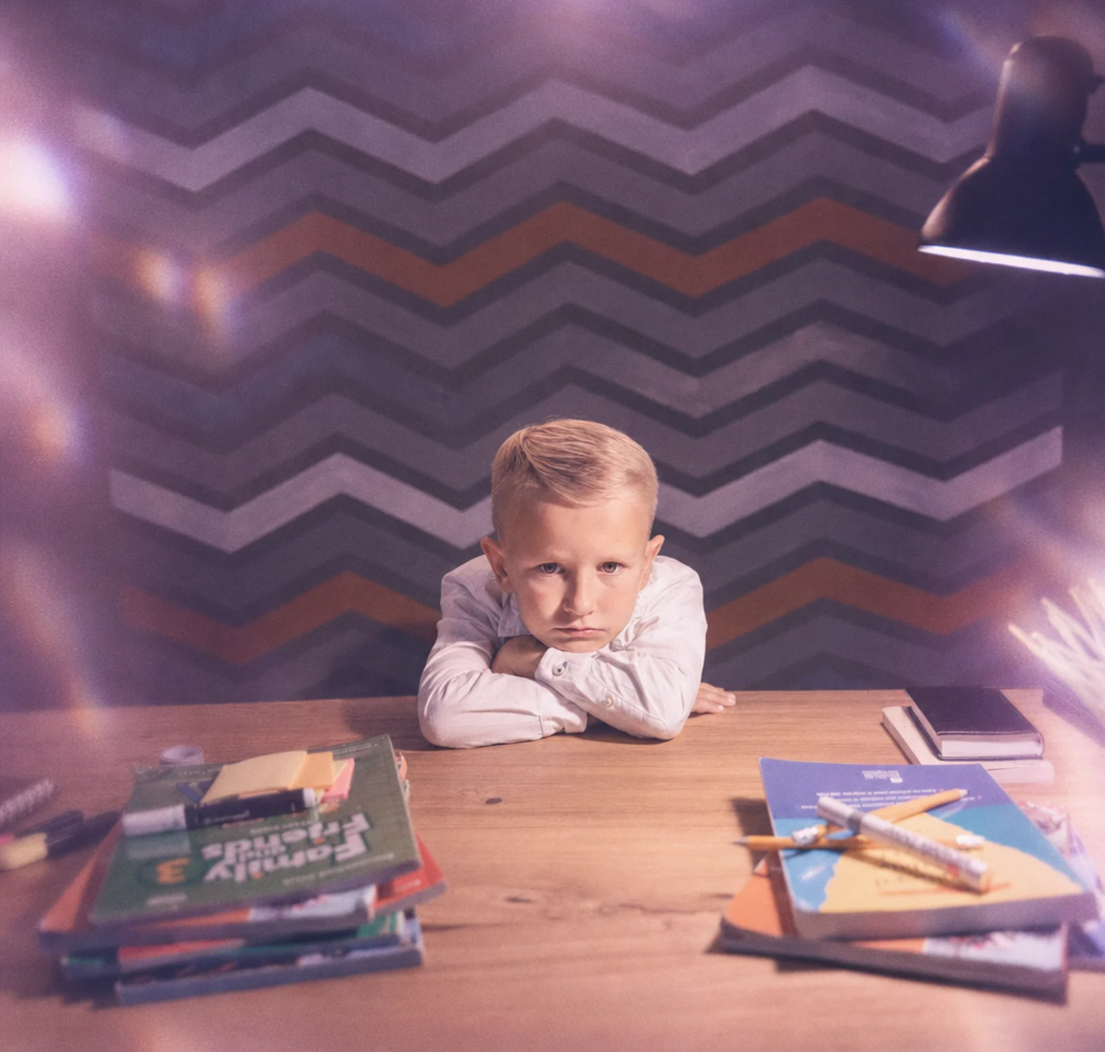 A child at a desk surrounded by books and school supplies