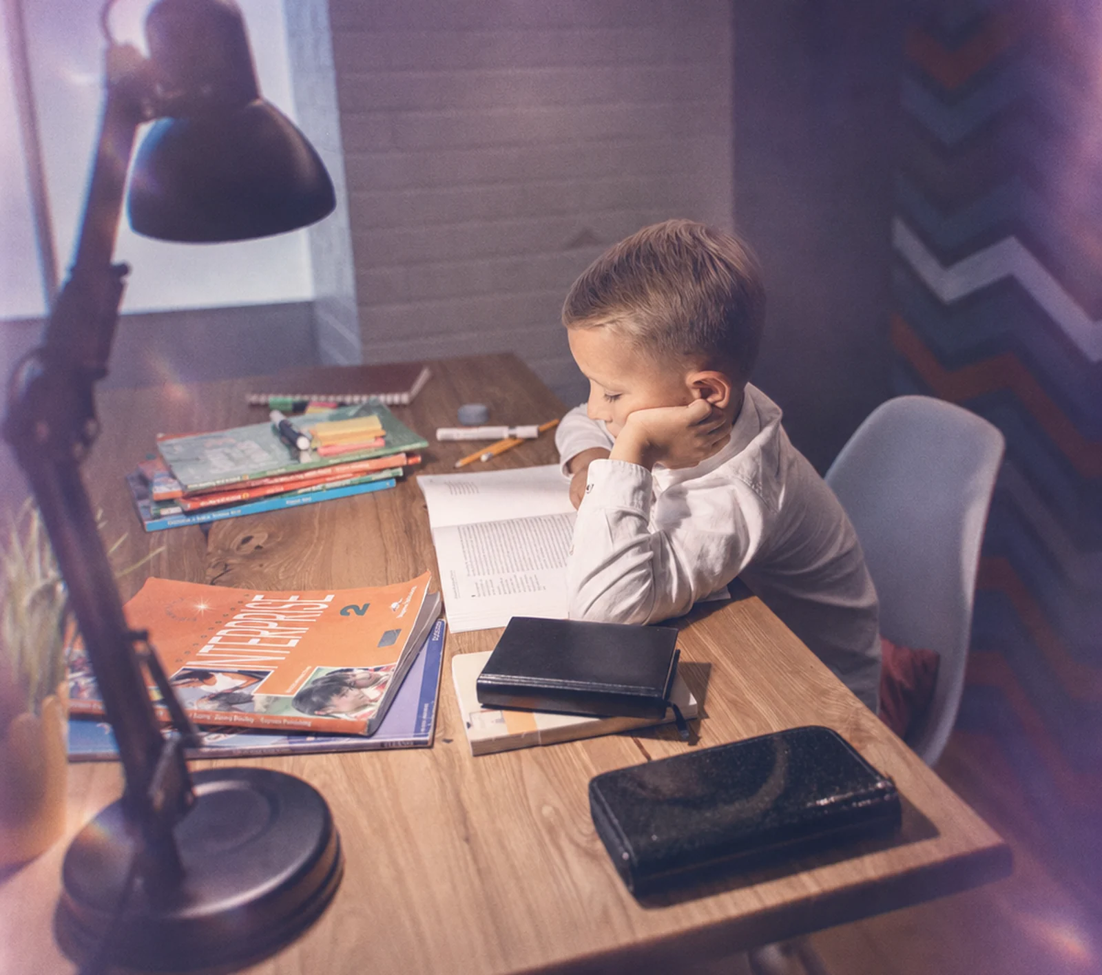 A parent waving during a virtual ABA session while her toddler plays beside her