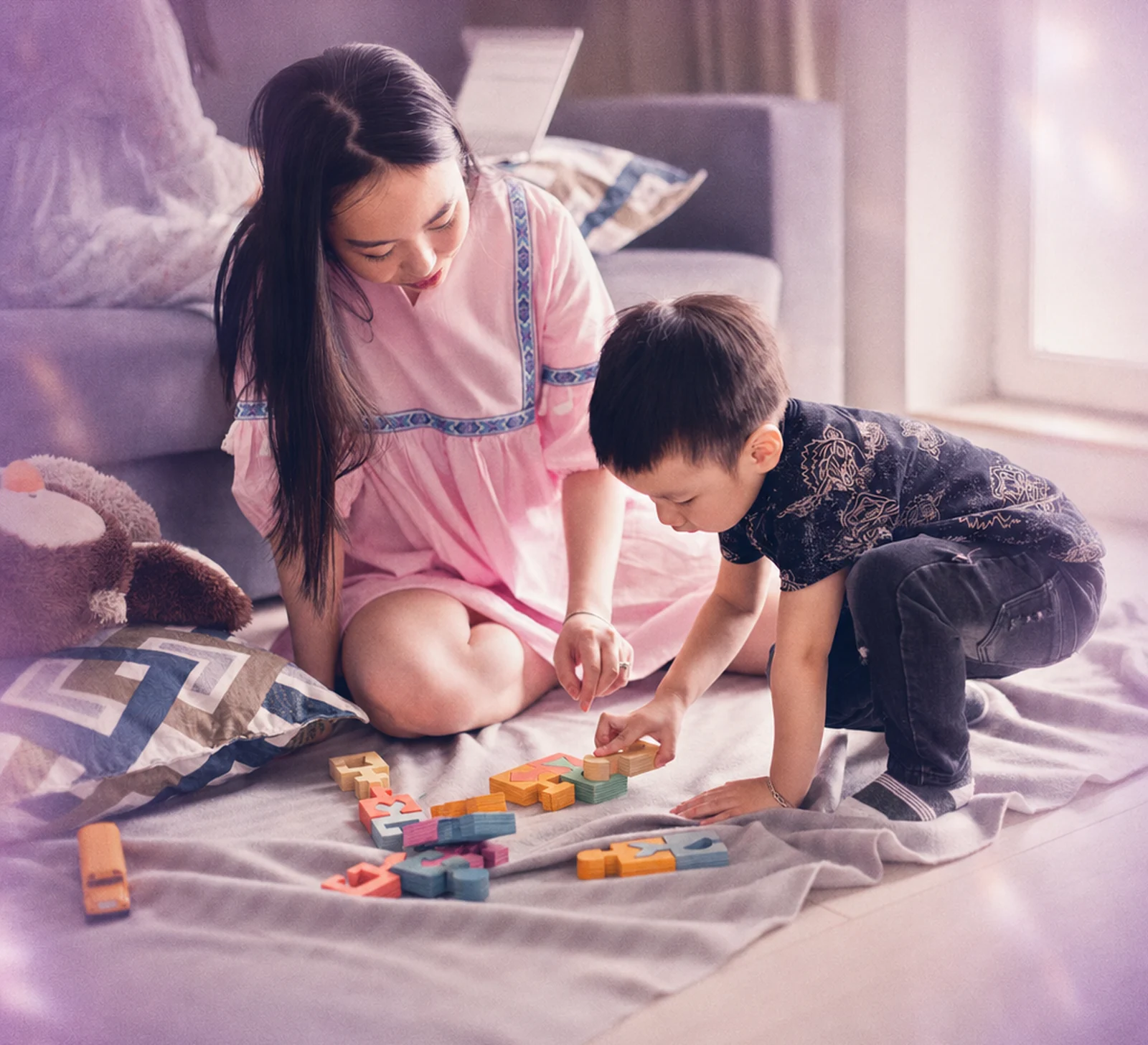 A parent and toddler waving during a video call at home