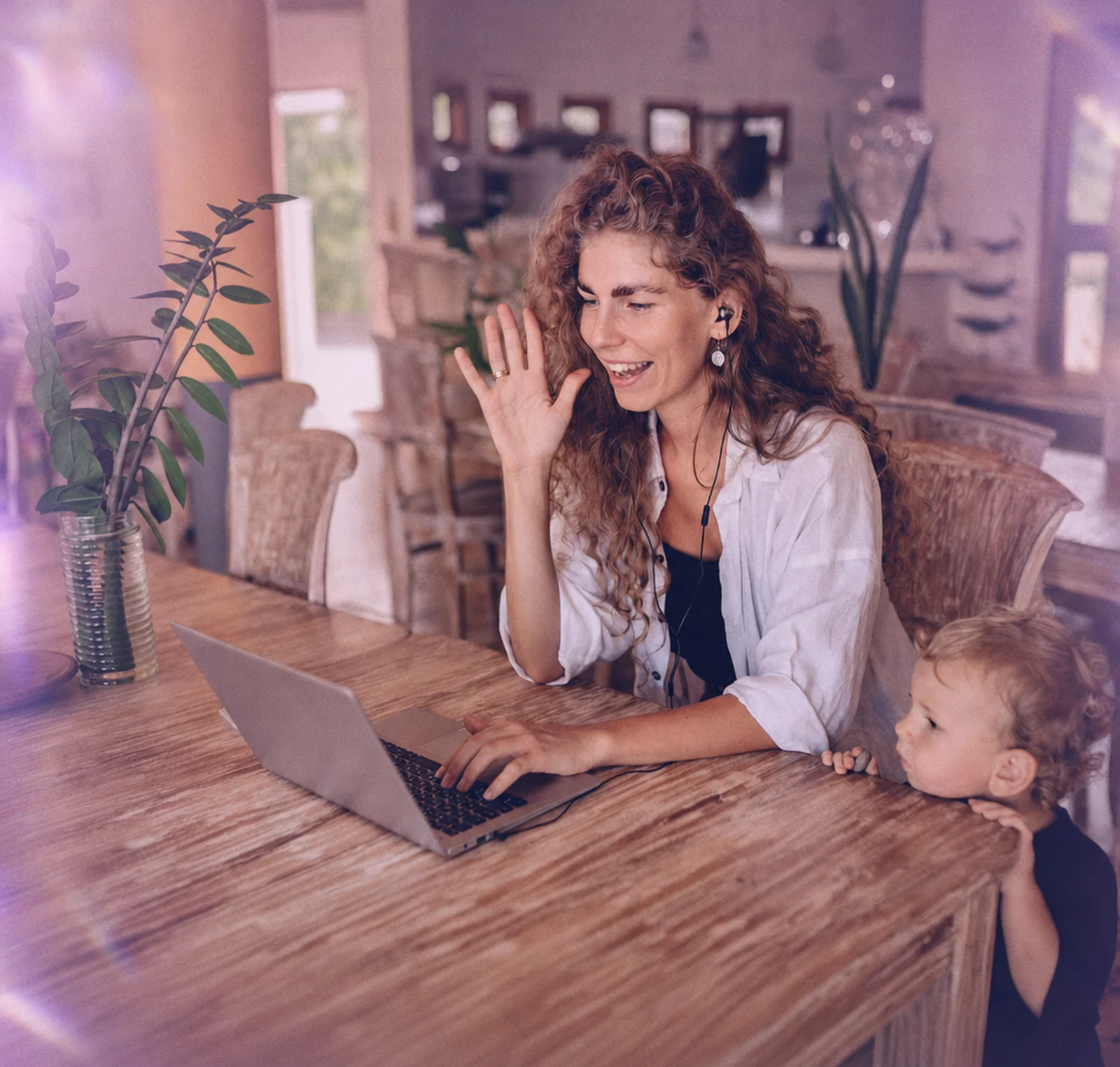 A parent and child on a video call at the kitchen table