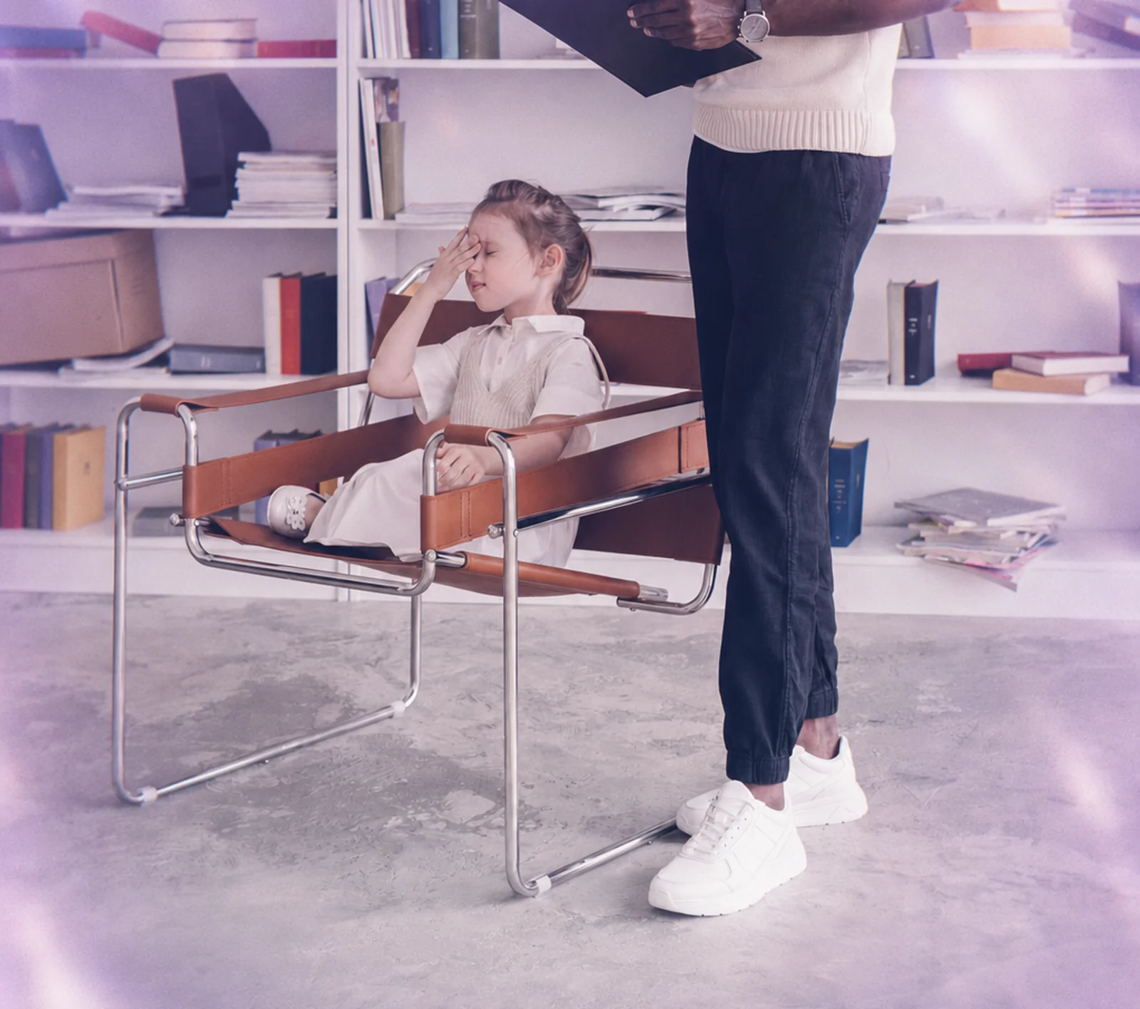 A parent waving during a virtual ABA session while her toddler plays beside her