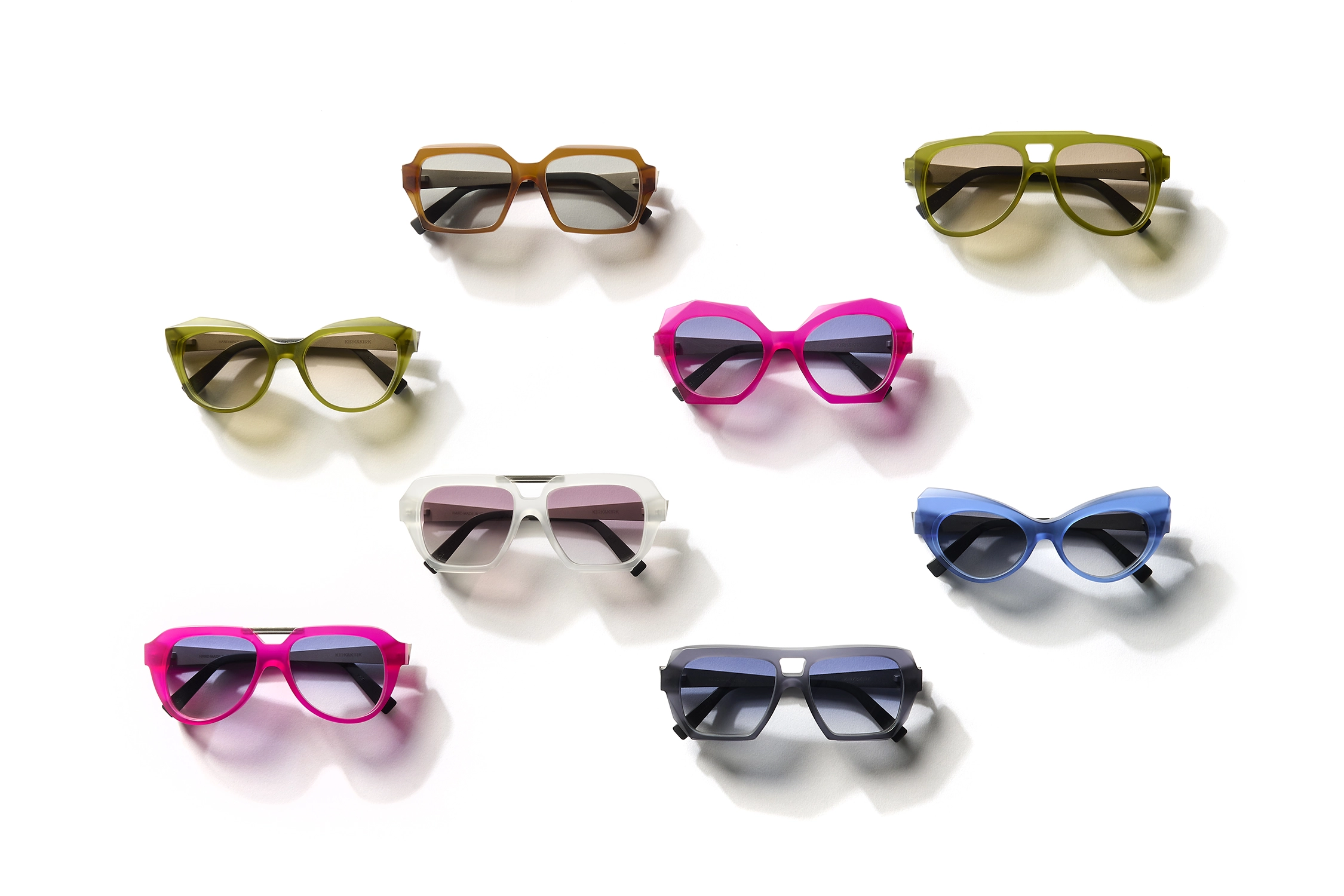 Eight pairs of colourful designer sunglasses arranged on a white background, showcasing bold geometric and fashion-forward frame styles