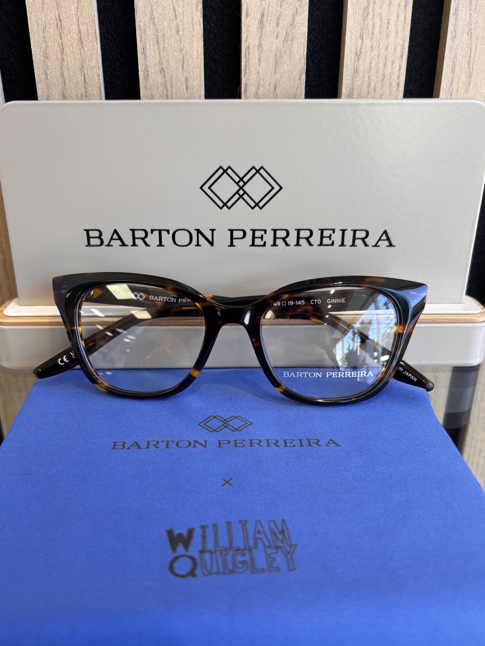 Barton Perreira tortoiseshell cat-eye eyeglass frames displayed with branded presentation materials