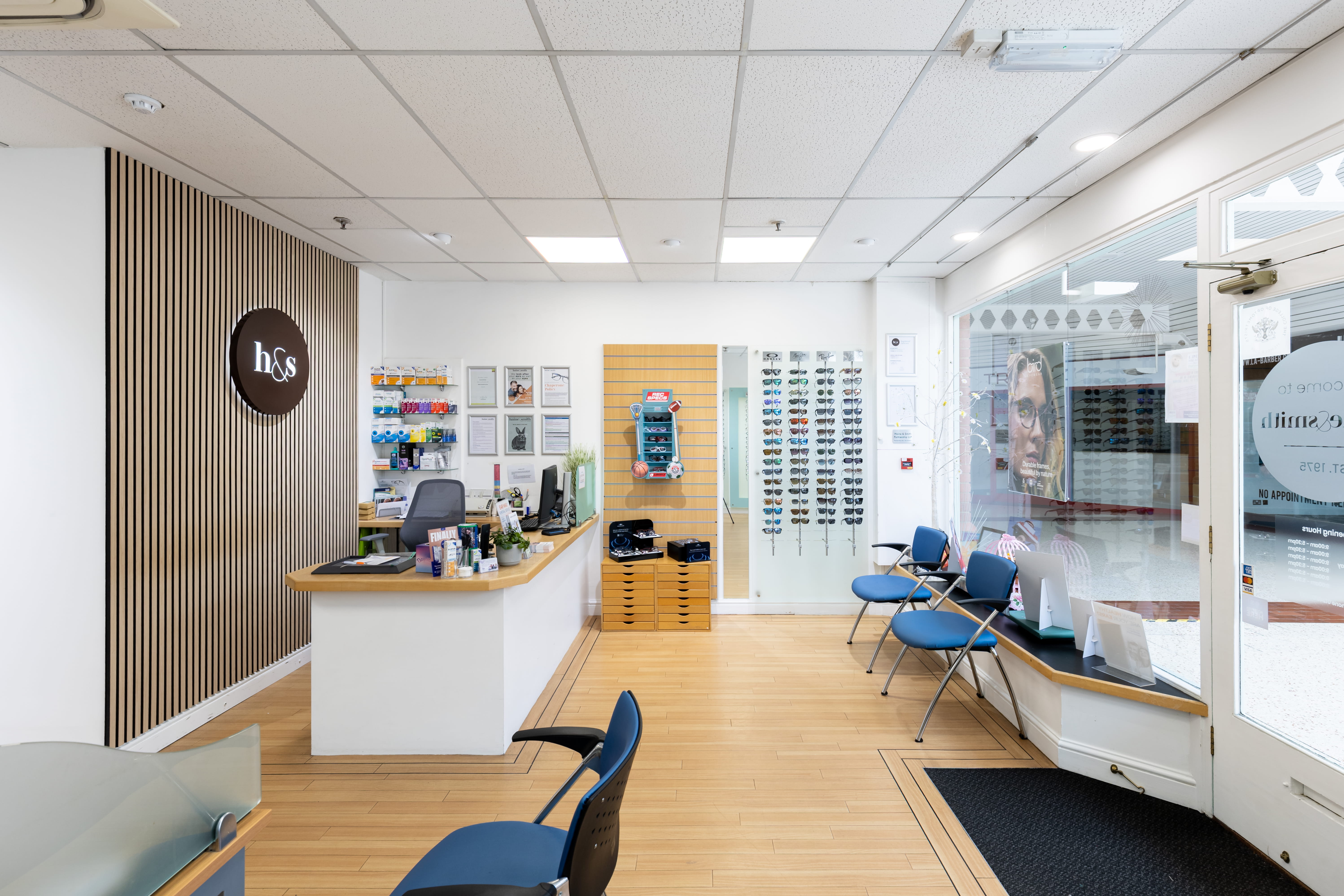 Bright and welcoming Haine & Smith Opticians practice interior featuring a reception desk, waiting area, eyewear displays, and a modern environment for eye care and hearing appointments