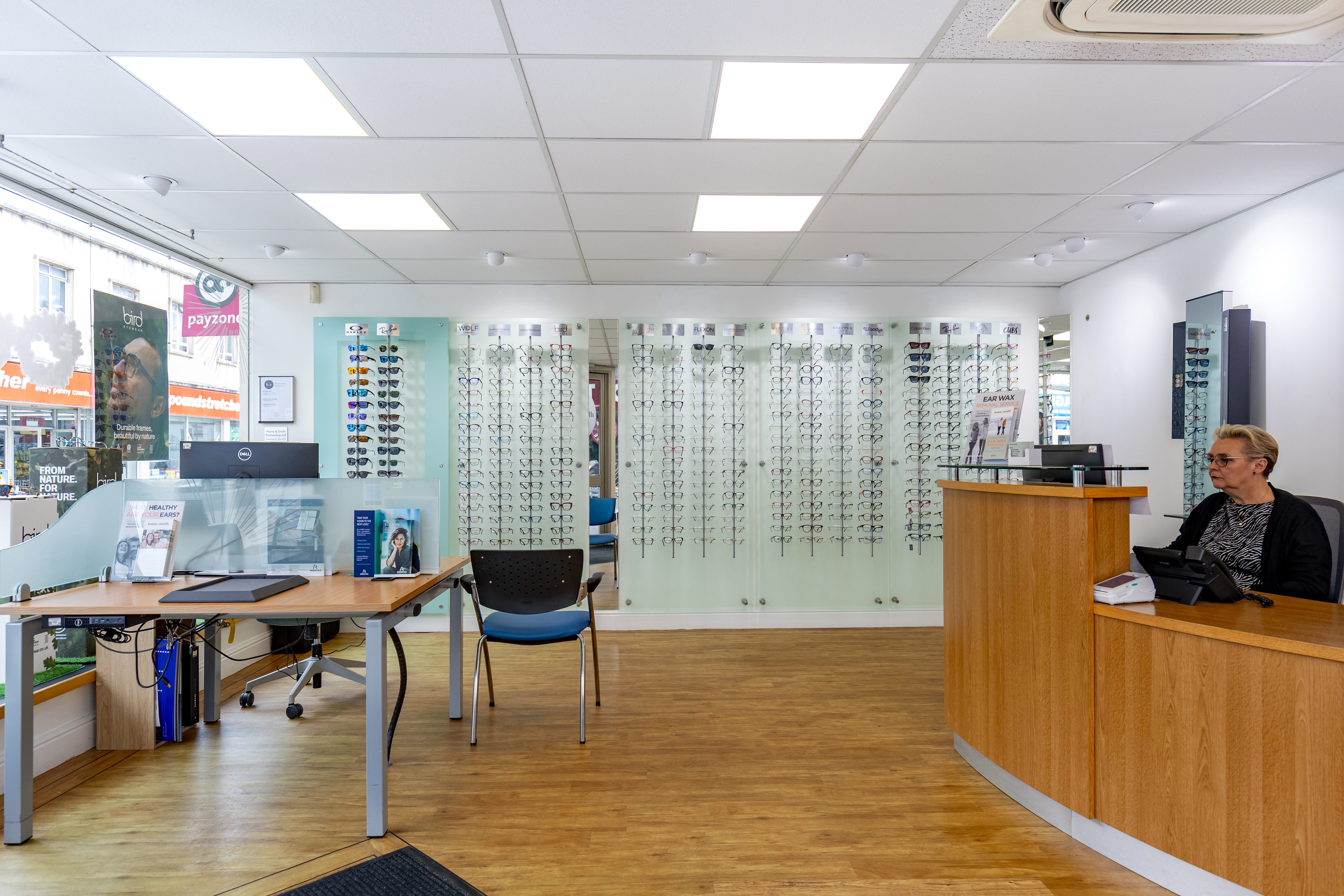 Modern Haine & Smith Opticians practice interior featuring a reception desk, eyewear display walls, consultation area, and a wide selection of prescription glasses and sunglasses