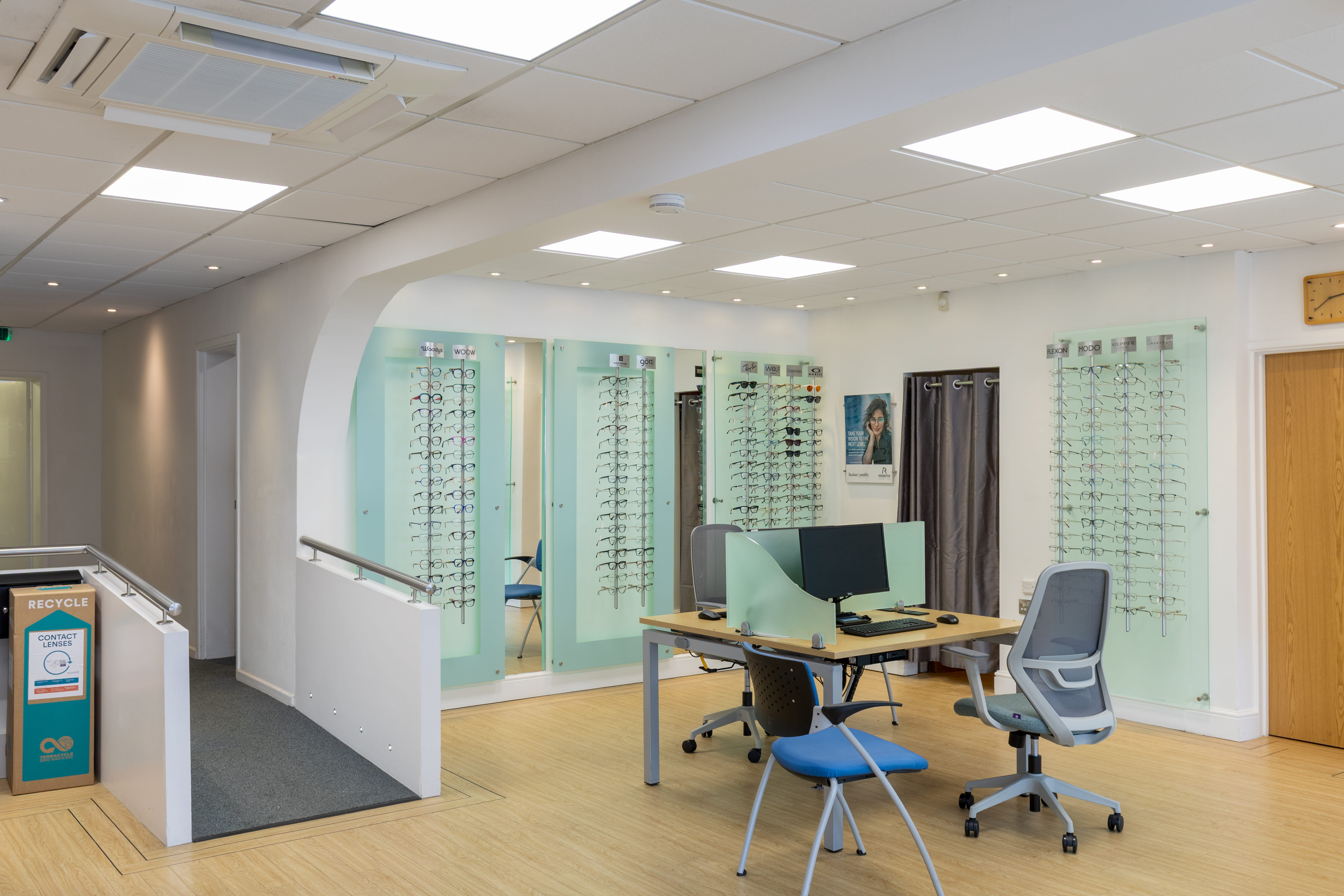 Bright and modern Haine & Smith opticians showroom featuring consultation desks, reception area, eyewear displays, customer seating, and an open-plan practice layout