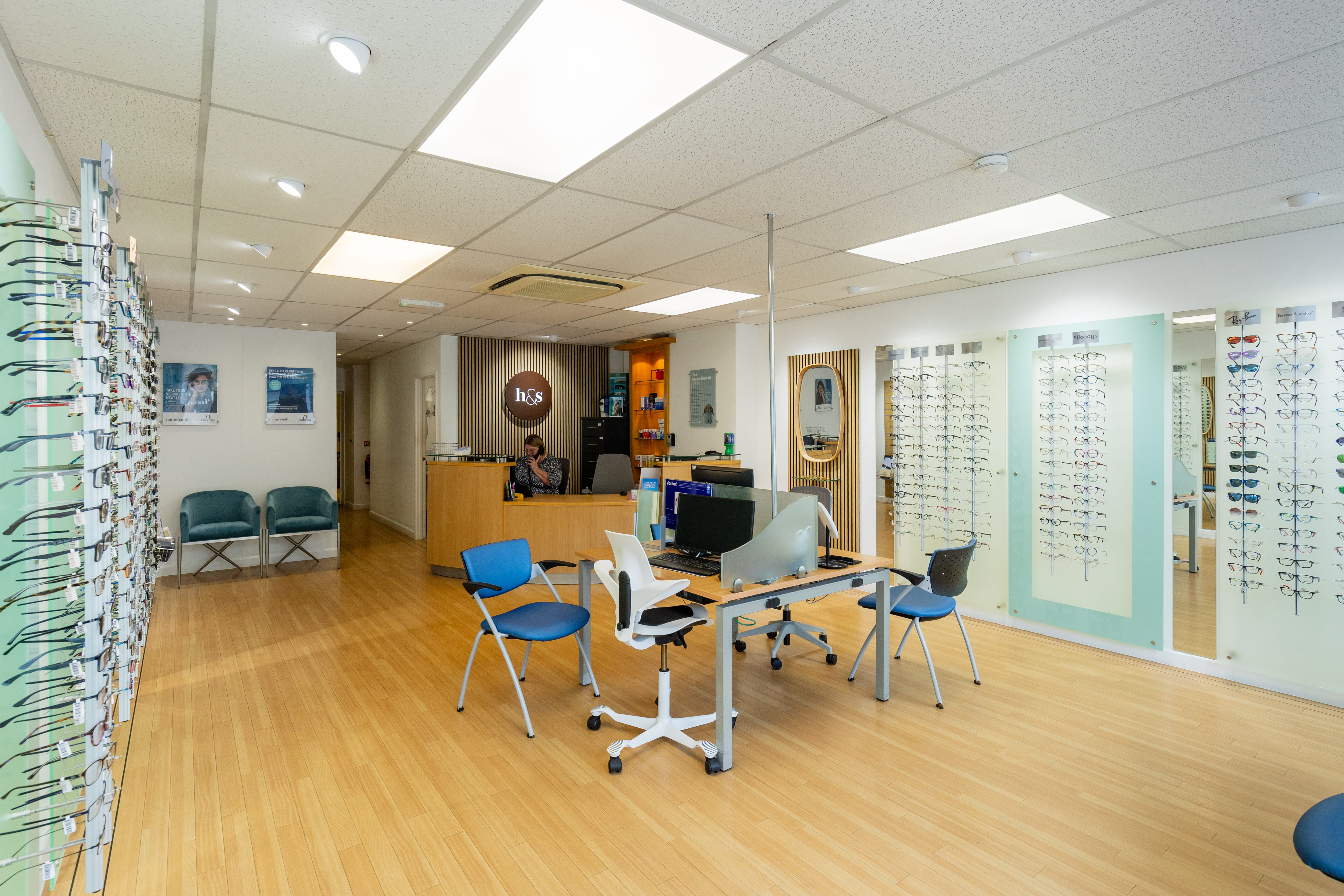 Bright and modern Haine & Smith Opticians showroom featuring eyewear displays, consultation desks, reception area, customer seating, and a wide selection of prescription frames
