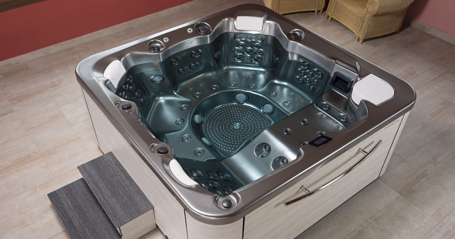 Grote hoogwaardige jacuzzi met zitplaatsen en hoofdkussens in een binnenruimte met tegelvloer.