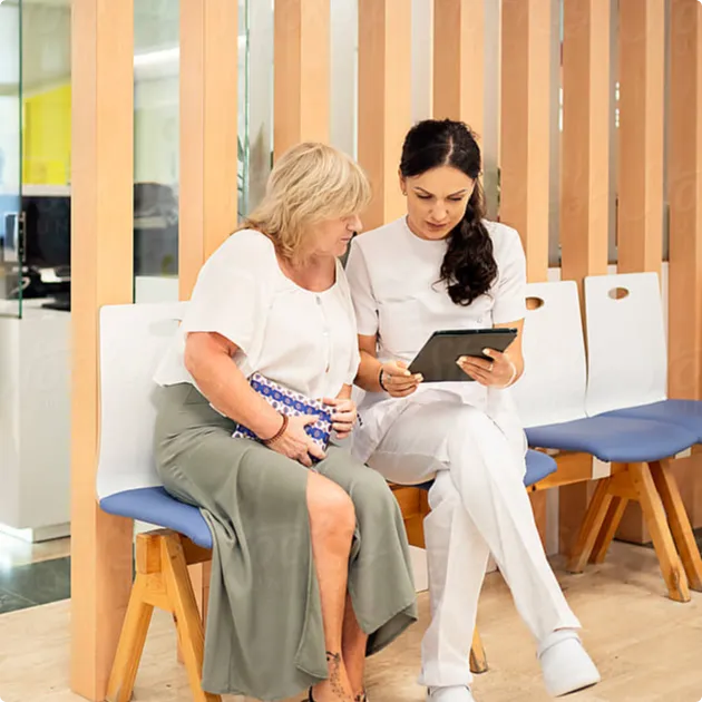 Provider sitting next to patient, showing her the result from a recent test on an ipad. 