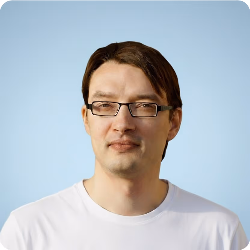 A man with glasses wearing a white t-shirt, looking directly at the camera with a neutral expression.

