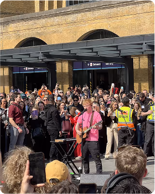 Ed Sheeran playing music for the crowd in the  street