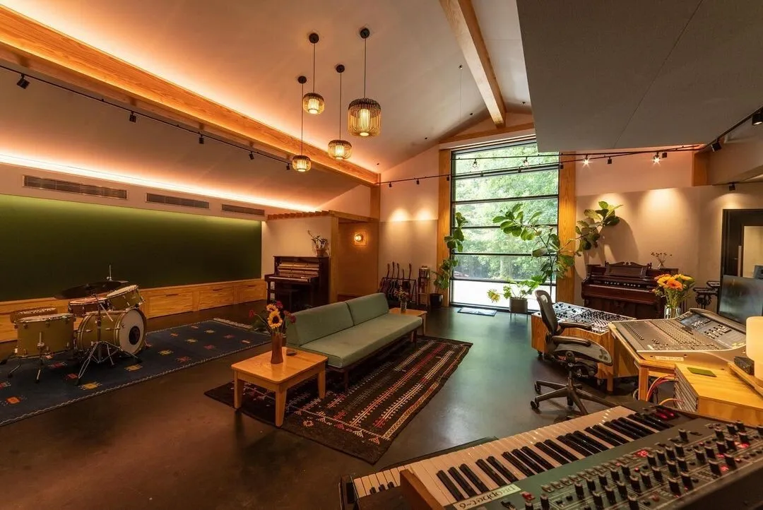 A recording studio featuring a couch, keyboard, and various music equipment, ready for creative sessions.